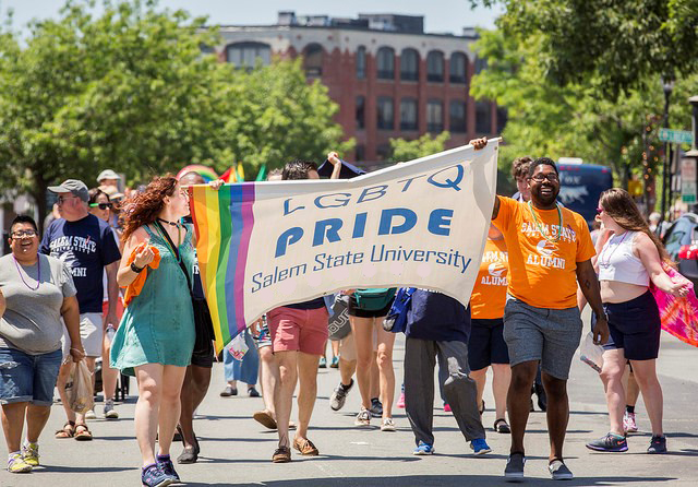 LGBTQ+ parade walkers with pride banner